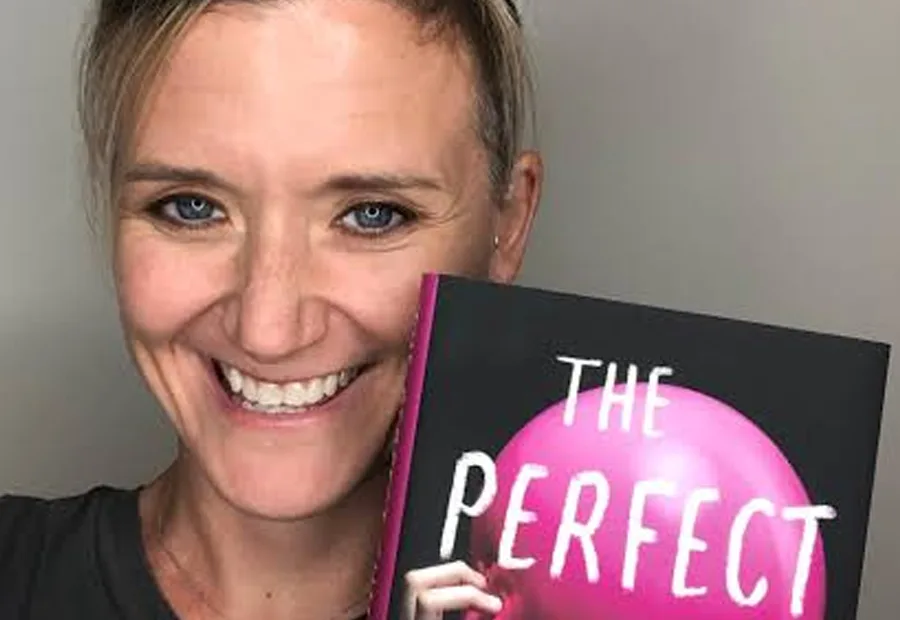 Lucinda Berry smiling while holding a copy of The Perfect Child